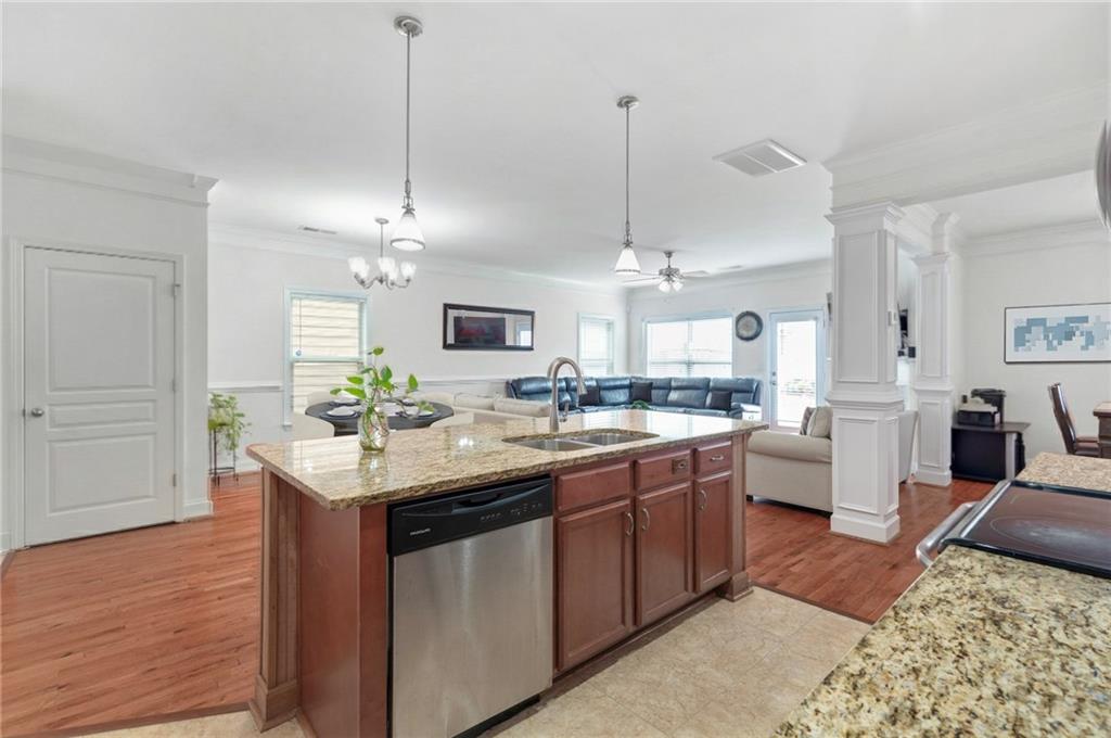 2325 Arnold Mill Road Northwest Lawrenceville, GA 30044 - Photo 16 of 40 a kitchen with kitchen island granite countertop a sink stove and wooden floor