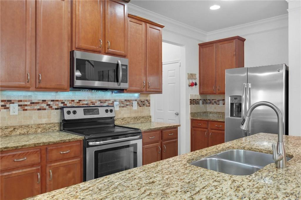 2325 Arnold Mill Road Northwest Lawrenceville, GA 30044 - Photo 17 of 40 a kitchen with stainless steel appliances granite countertop a sink stove and refrigerator