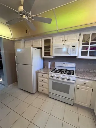 a kitchen with a stove top oven cabinets and a refrigerator