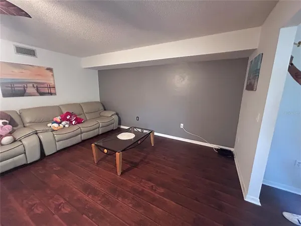 a living room with furniture and wooden floor