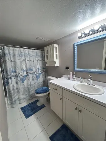 a spacious bathroom with a double vanity sink a toilet and a mirror