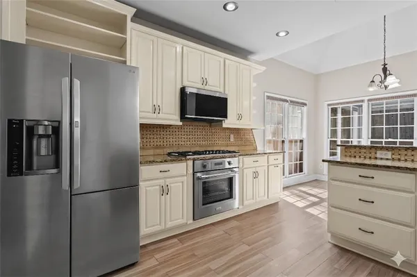 a kitchen with white cabinets and stainless steel appliances