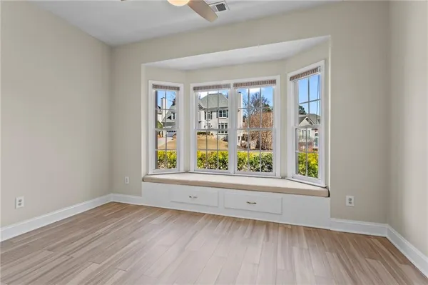 an empty room with wooden floor and windows