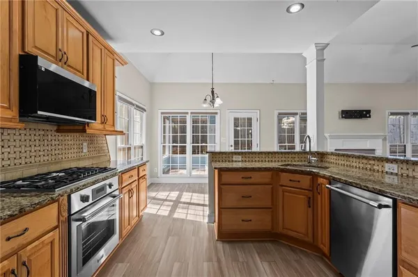 a kitchen with stainless steel appliances granite countertop a stove and cabinets