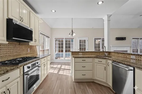a kitchen with stainless steel appliances granite countertop a stove and cabinets