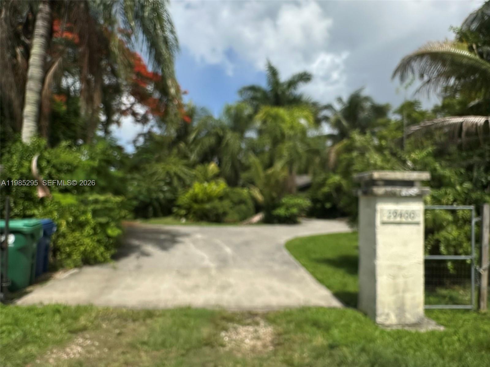 29400 Southwest 179th Avenue Homestead, FL 33030 - Photo 2 of 49 a view of a yard with plants and a bench