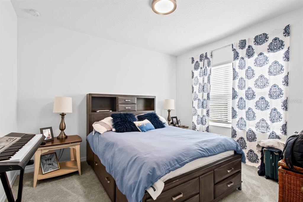 6262 Goldcoast Avenue Apollo Beach, FL 33572 - Photo 19 of 65 a bedroom with a bed and a chair