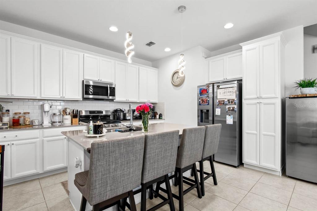 6262 Goldcoast Avenue Apollo Beach, FL 33572 - Photo 9 of 65 a kitchen with granite countertop a center island stainless steel appliances cabinets and a counter top space