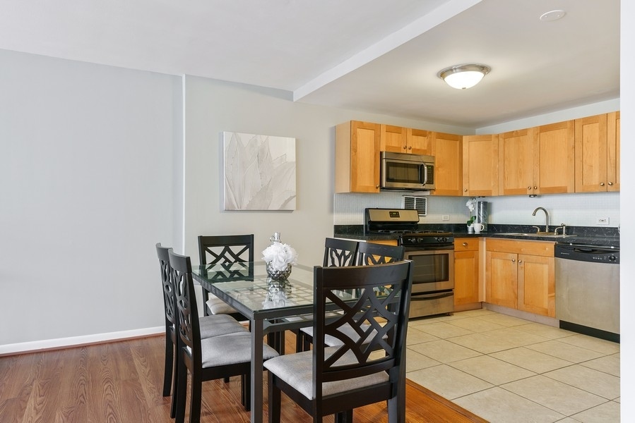 400 East Randolph Street, Unit 3324 Chicago, IL 60601 - Photo 11 of 28 a kitchen with granite countertop a stove a sink and a microwave