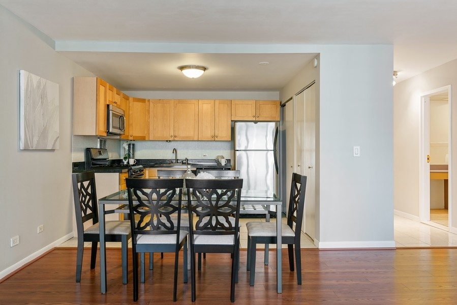 400 East Randolph Street, Unit 3324 Chicago, IL 60601 - Photo 12 of 28 a view of a dining room with furniture and wooden floor