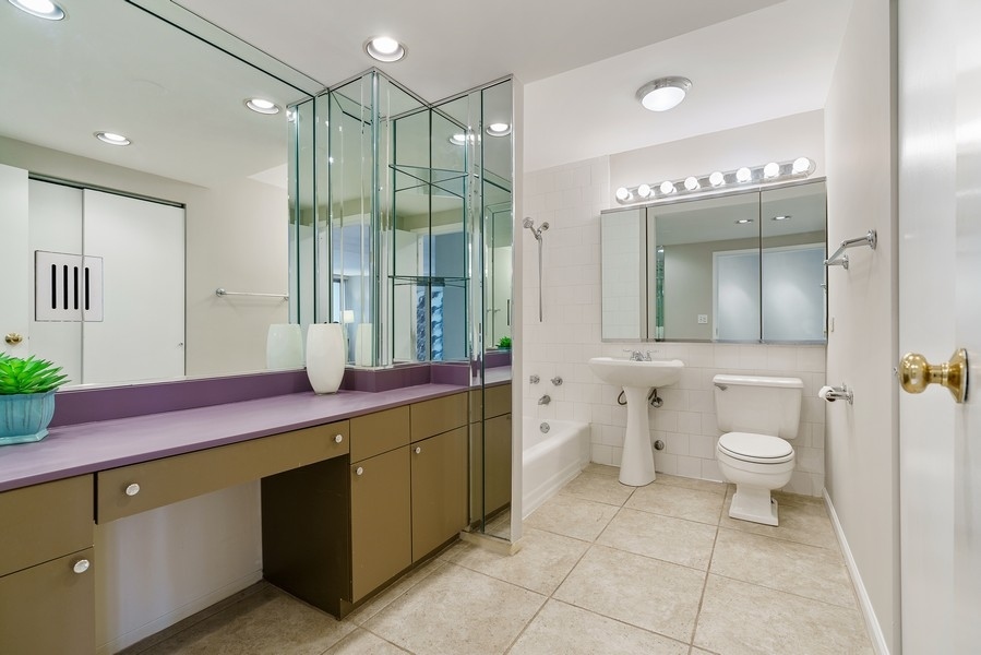 400 East Randolph Street, Unit 3324 Chicago, IL 60601 - Photo 16 of 28 a spacious bathroom with a granite countertop sink a toilet and a shower