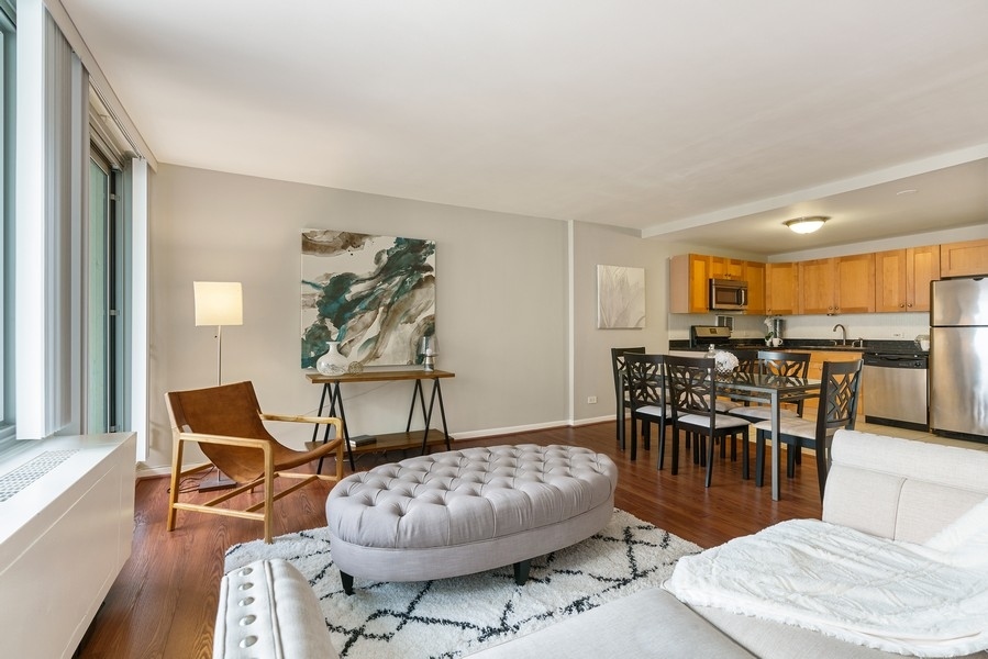 400 East Randolph Street, Unit 3324 Chicago, IL 60601 - Photo 7 of 28 a living room with furniture and a dining table with wooden floor