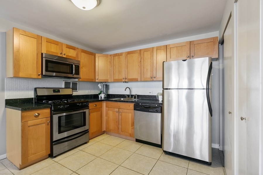 400 East Randolph Street, Unit 3324 Chicago, IL 60601 - Photo 9 of 28 a kitchen with stainless steel appliances granite countertop a refrigerator stove a sink and a microwave