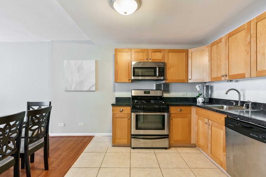 400 East Randolph Street, Unit 3324 Chicago, IL 60601 - Photo 10 of 28 a kitchen with stainless steel appliances granite countertop a stove microwave and sink