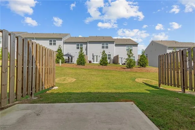 a view of a house next to a yard with big trees