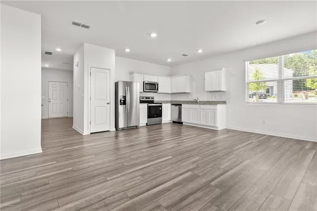 a view of kitchen with wooden floor and electronic appliances