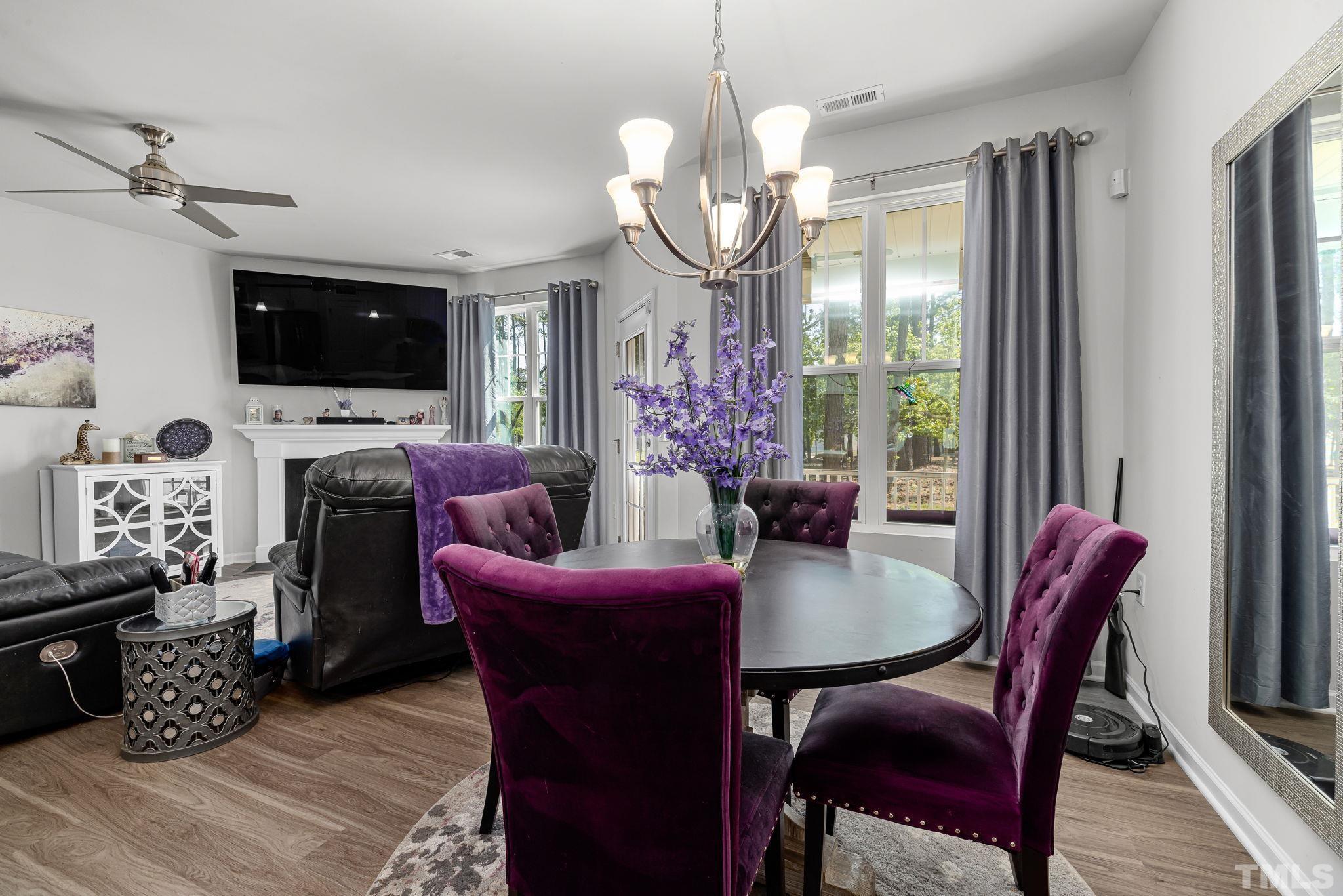 6084 Beale Loop Raleigh, NC 27616 - Photo 12 of 30 a view of a dining room with furniture a flat screen tv and a chandelier