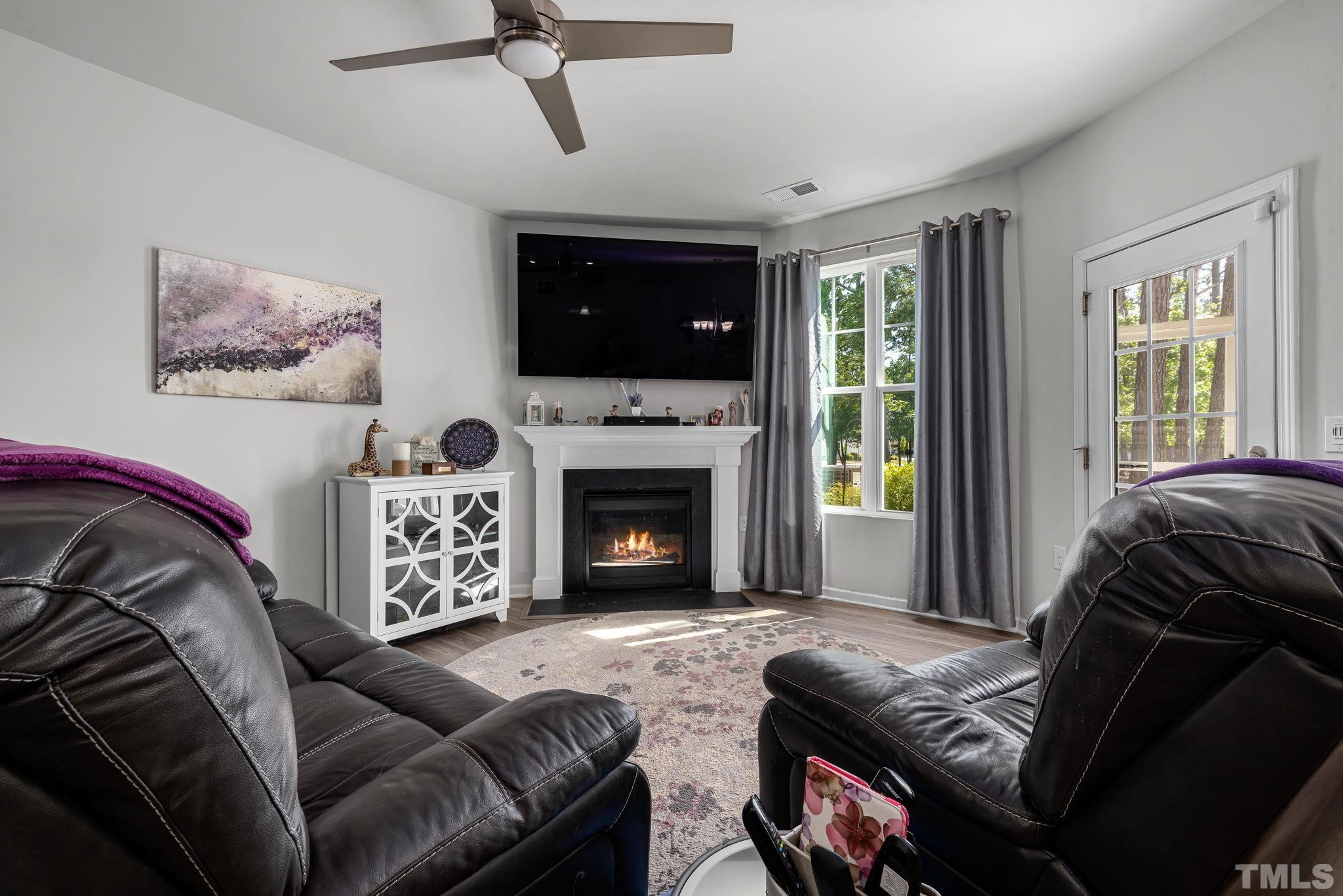 6084 Beale Loop Raleigh, NC 27616 - Photo 8 of 30 a living room with furniture a flat screen tv and a fireplace