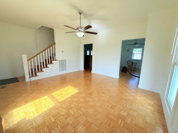 a view of a livingroom with a piano and wooden floor