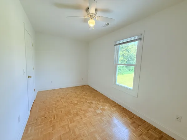 an empty room with fan and entrance
