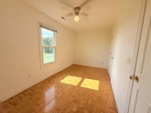 a view of a hallway with a chandelier fan and wooden floor