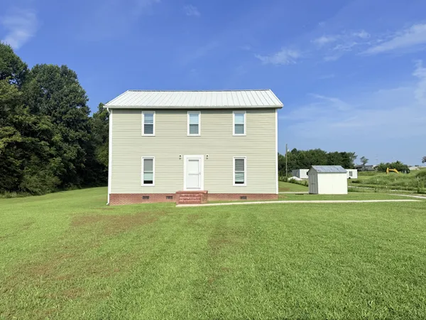 a view of a green field with wooden fence