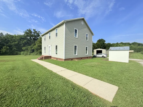 a view of a backyard with a garden and entertaining space