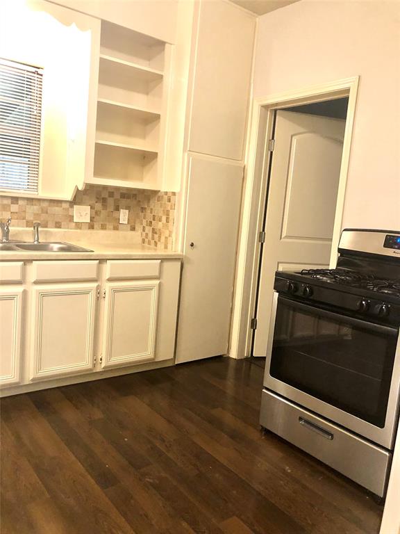 905 Isbell Road Fort Worth, TX 76114 - Photo 15 of 29 Kitchen featuring white cabinetry, dark hardwood / wood-style floors, gas range, and sink