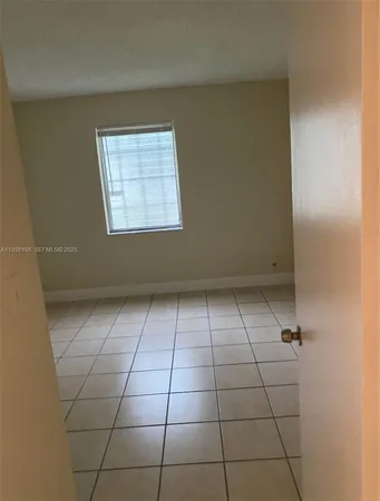 a view of a livingroom with an empty space and a window