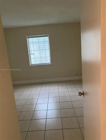 a view of a livingroom with an empty space and a window