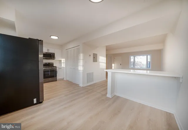a view of kitchen with wooden floor and electronic appliances