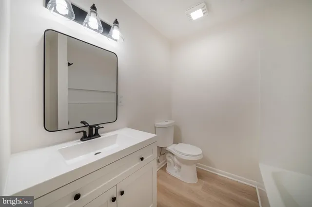 a bathroom with a sink a toilet a mirror and shower