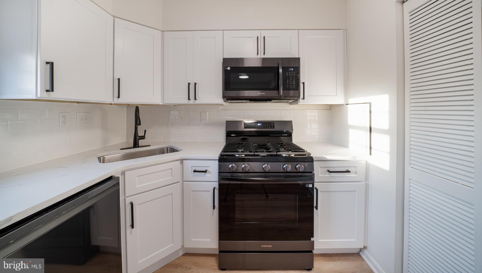4631 Minnesota Avenue Northeast Washington, DC 20019 - Photo 9 of 28 a kitchen with stainless steel appliances granite countertop white cabinets and black stove top oven with granite countertops