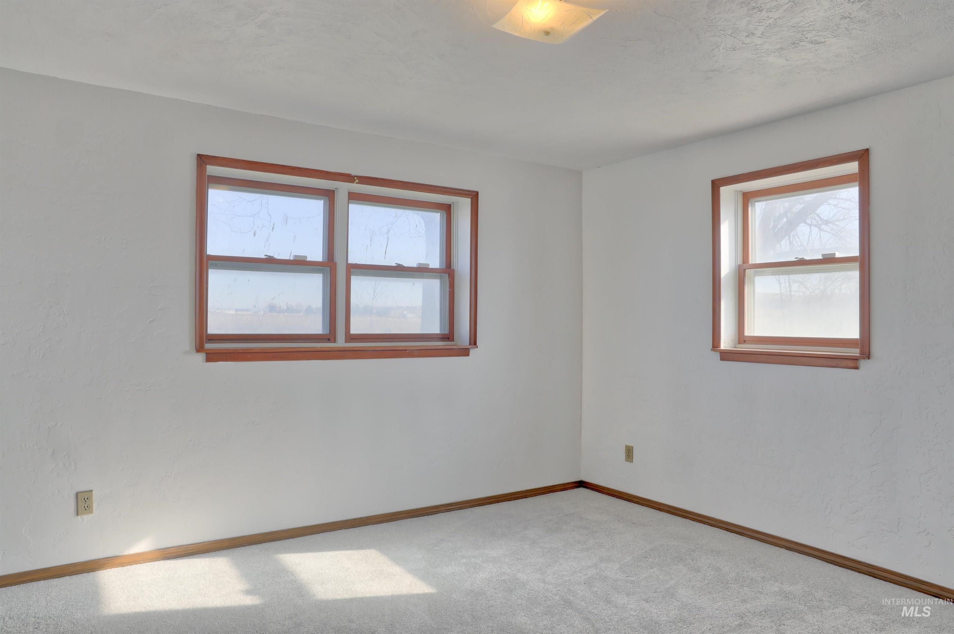 8027 Chuckar Lane Boise, ID 83709 - Photo 14 of 19 Carpeted spare room with baseboards and a textured ceiling