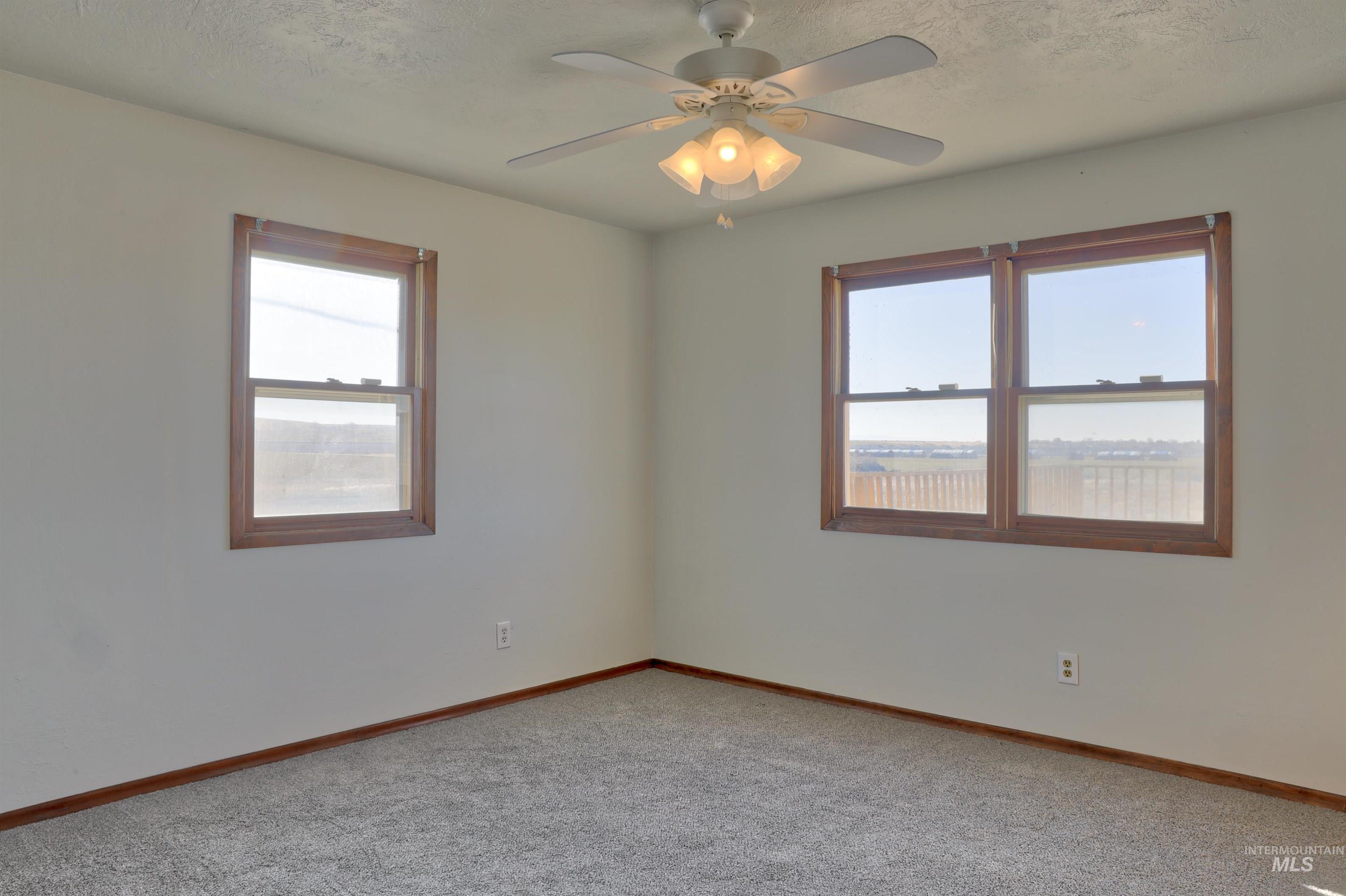 8027 Chuckar Lane Boise, ID 83709 - Photo 10 of 19 Carpeted spare room featuring healthy amount of natural light, a textured ceiling, and ceiling fan