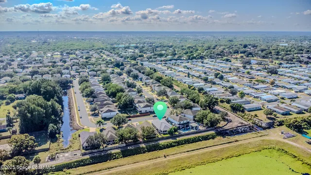 an aerial view of residential houses with outdoor space and trees