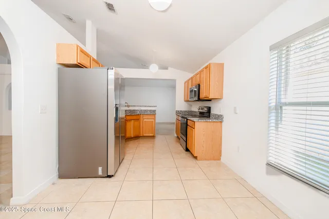 a kitchen with stainless steel appliances granite countertop a refrigerator and a stove