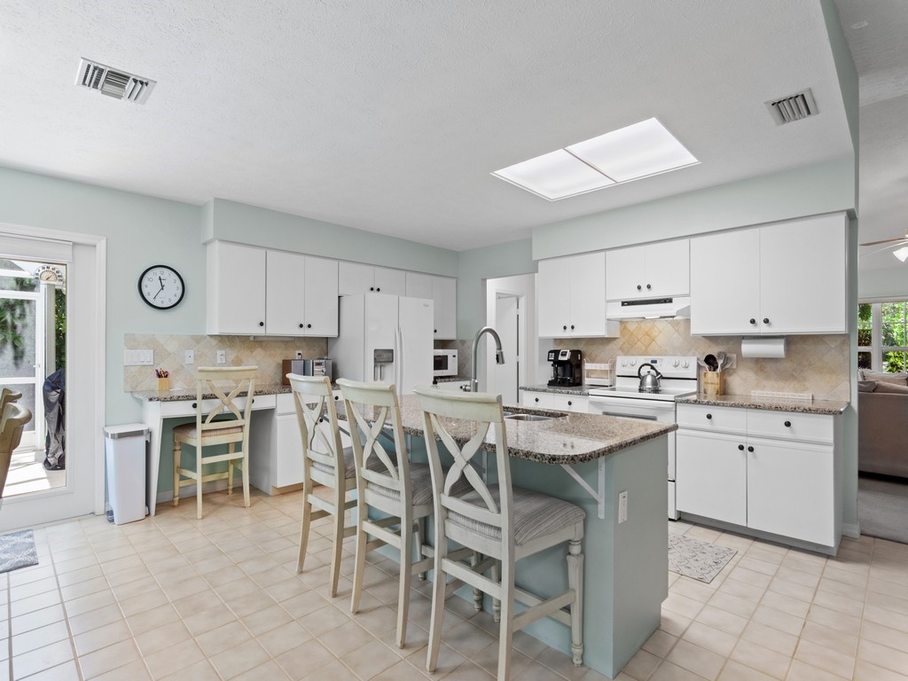 765 Date Palm Road Vero Beach, FL 32963 - Photo 12 of 36 a kitchen with cabinets and chairs