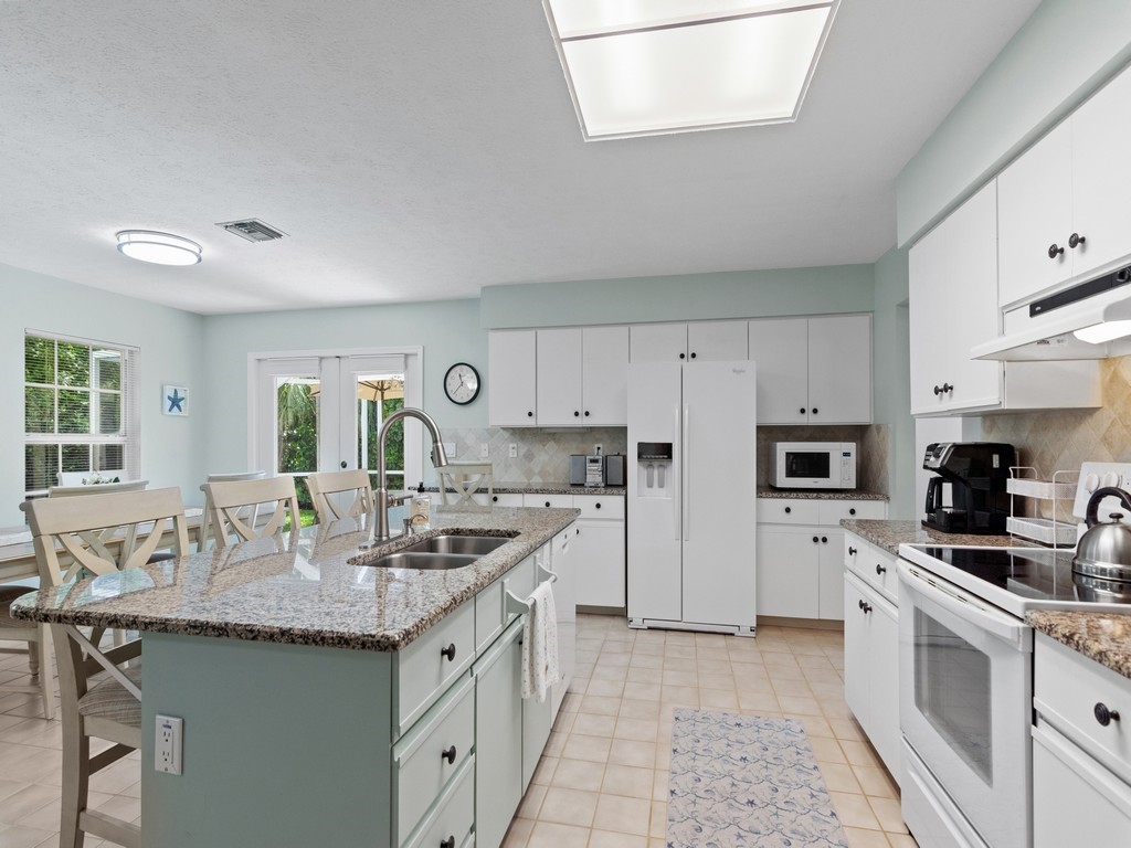 765 Date Palm Road Vero Beach, FL 32963 - Photo 15 of 36 a kitchen with stainless steel appliances granite countertop a sink and cabinets
