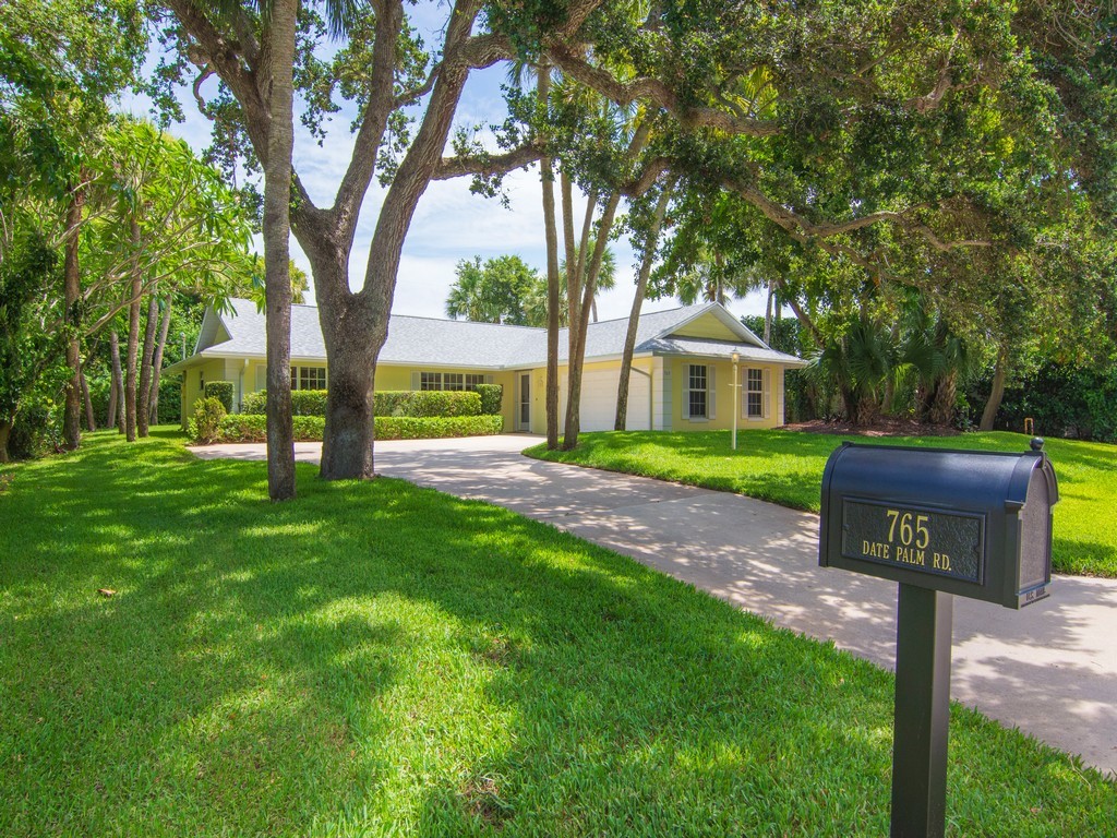 765 Date Palm Road Vero Beach, FL 32963 - Photo 2 of 36 a front view of a house with garden and tree s