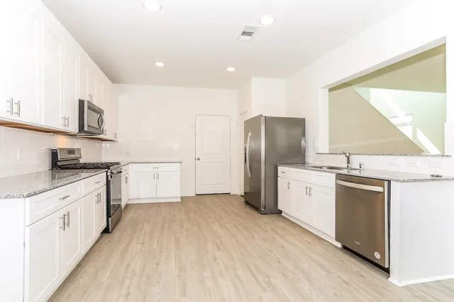 an empty room with windows and fan