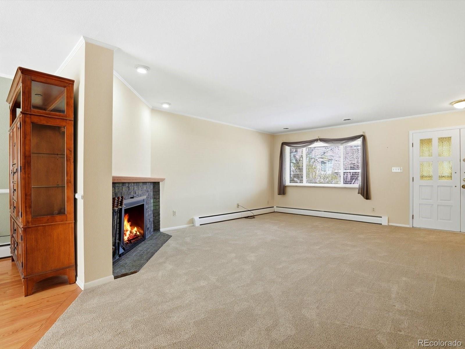 3330 South Oneida Way Denver, CO 80224 - Photo 3 of 36 an empty room with windows and fireplace