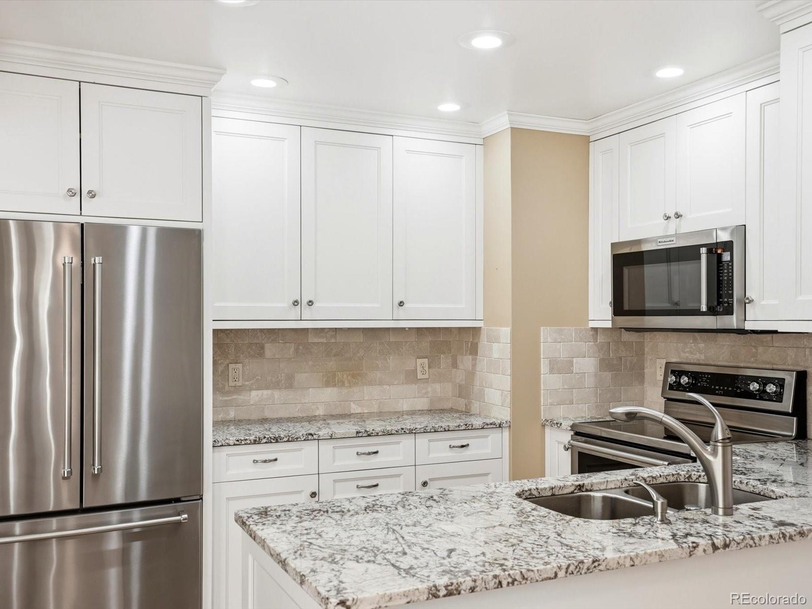 3330 South Oneida Way Denver, CO 80224 - Photo 7 of 36 a kitchen with stainless steel appliances granite countertop a refrigerator stove and sink