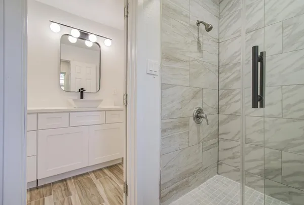 a bathroom with a shower sink and mirror