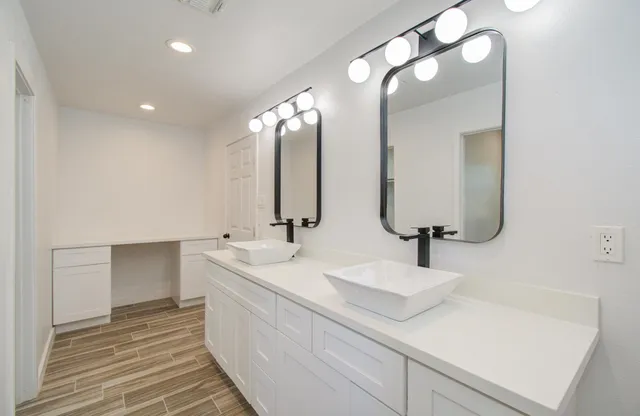 a bathroom with double vanity and a mirror
