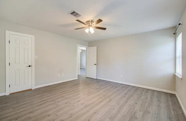 a view of an empty room with wooden floor