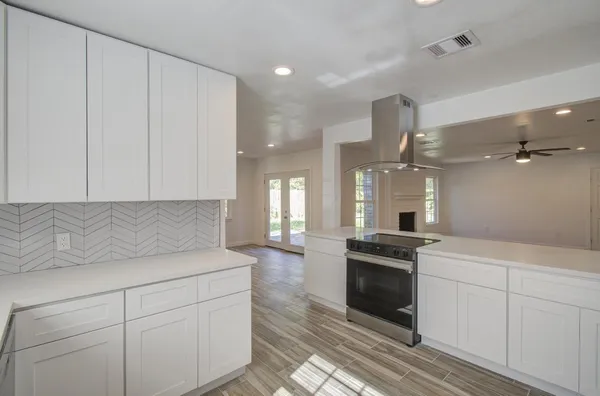 a kitchen with granite countertop white cabinets and stainless steel appliances