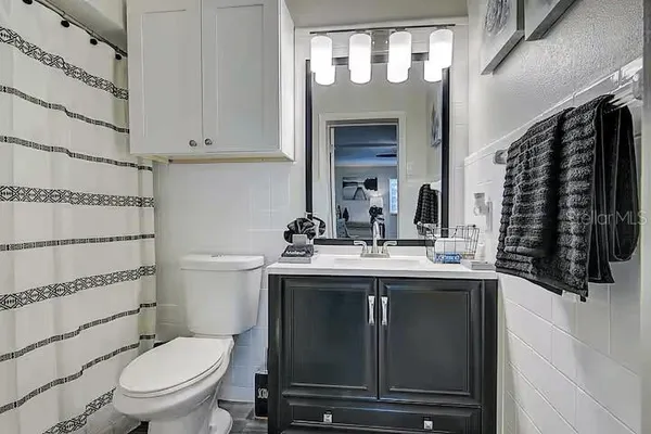 a bathroom with a granite countertop toilet sink and mirror
