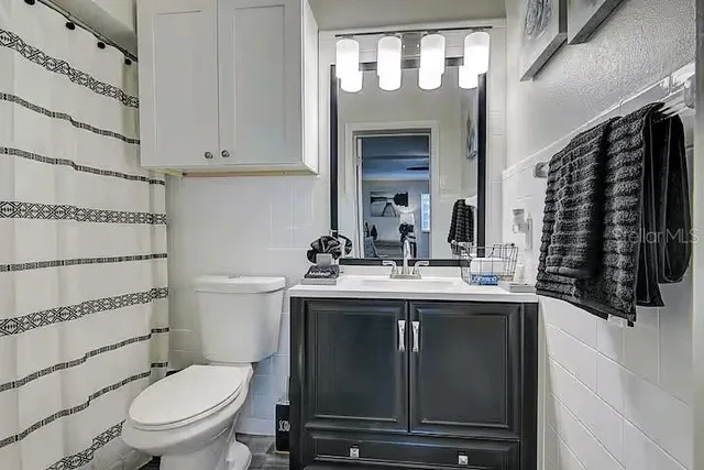 a bathroom with a granite countertop toilet sink and mirror