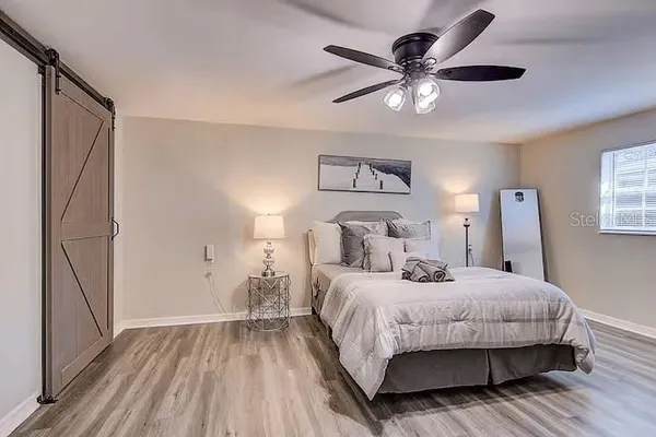 a bedroom with a bed and a ceiling fan